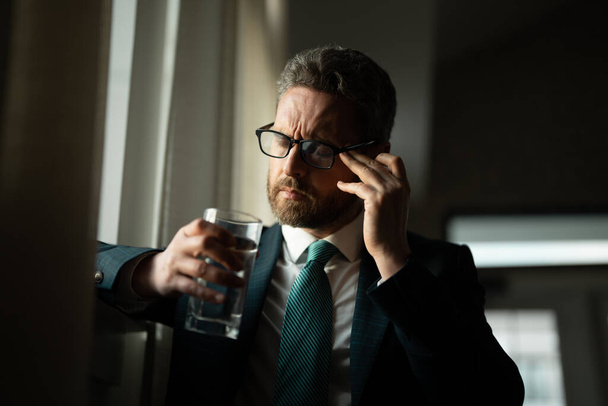 Tired, headache and eye strain from laptop. Businessman with stress, burnout and fatigue eyestrain. Business man rubbing tired eyes after computer work - Фото, изображение