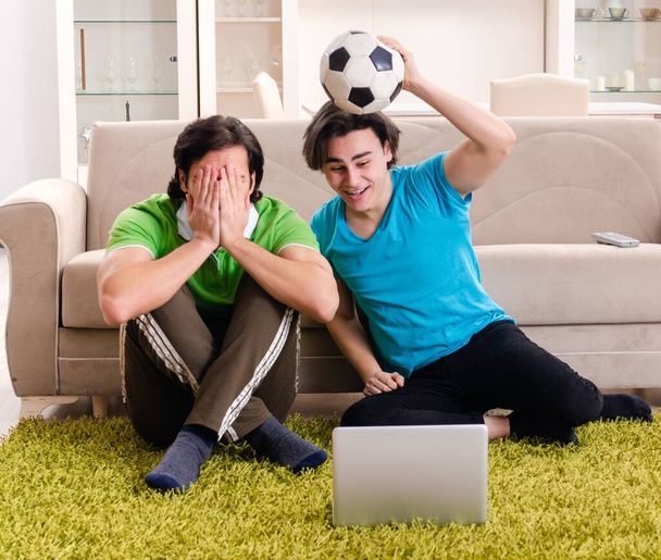 家でサッカーを見ている友達 - 写真・画像