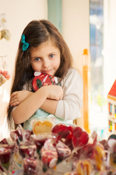 Greed  little girl with lollipop in candy store - Foto, Bild