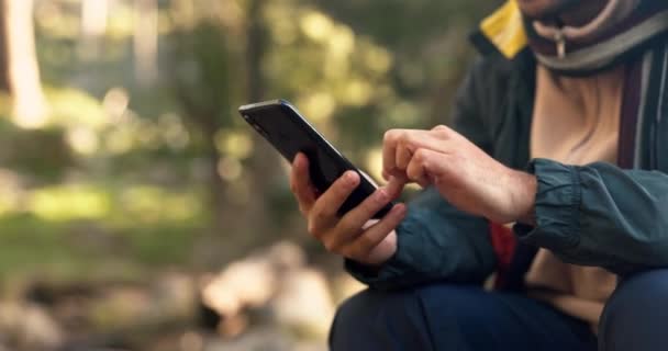 Hands, phone and man hiking in a forest texting, search and using map, navigation and travel guide in nature. Smartphone, app and male hiker online for location, sos or checking message in a jungle. - Footage, Video