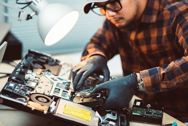 Techniker repariert einen kaputten Computer. Computer-Service und Reparaturkonzept. - Foto, Bild