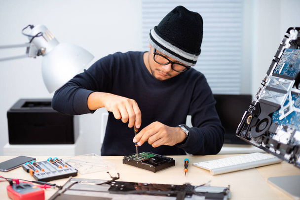 Technicus repareert een kapotte computer. Computer service en reparatie concept. - Foto, afbeelding