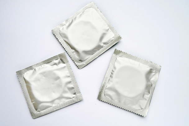 Três preservativos isolados em branco
 - Foto, Imagem