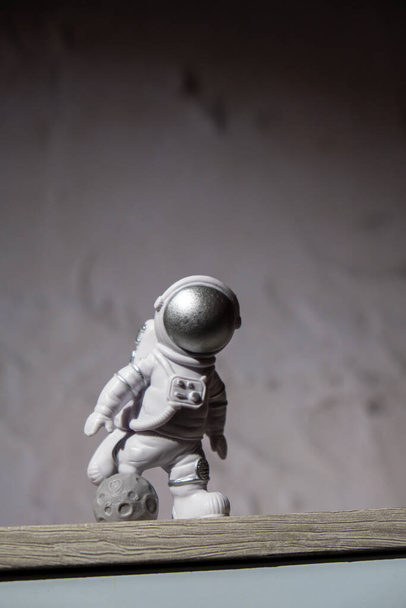 Plastic toy figure astronaut on moon concrete background Copy space. Concept of out of earth travel, private spaceman commercial flights. Space missions and Sustainability - Foto, imagen