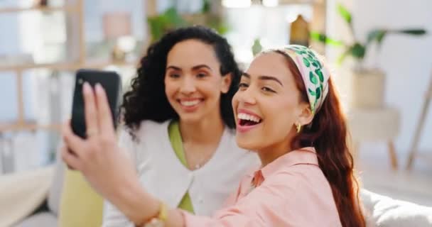 Women friends, selfie and smile on sofa, excited or together for social media, blog or post on web. Girl partnership, content creator and smartphone for memory, photography or profile picture in home. - Footage, Video