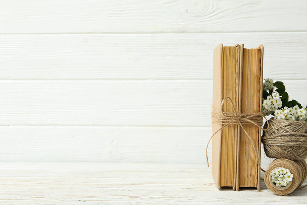 Książki i sznurki na białym drewnianym tle, miejsce na tekst - Zdjęcie, obraz