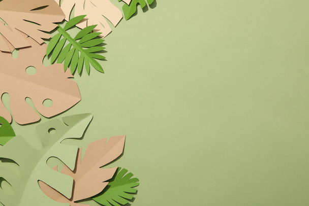 Χαρτί πράσινα τροπικά φύλλα σε πράσινο φόντο. Με ένα φλαμίνγκο πουλί. - Φωτογραφία, εικόνα