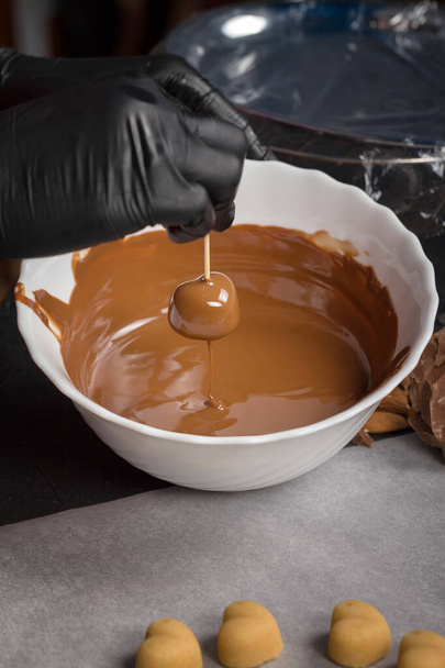 The process of making candies at home. Glazing milk chocolate candies. - Zdjęcie, obraz