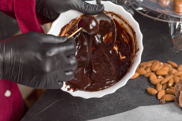 The process of making candies at home. Glazing black chocolate candies. - Zdjęcie, obraz