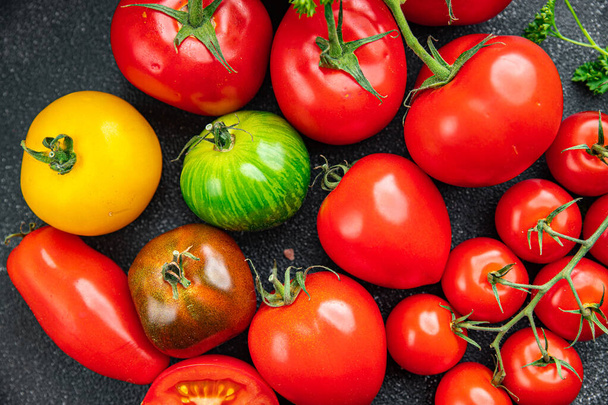 świeże pomidory różne rodzaje pomidorów czerwony, żółty, zielony posiłek warzywny jedzenie przekąska na stole kopia przestrzeń jedzenie tło rustykalny widok z góry - Zdjęcie, obraz