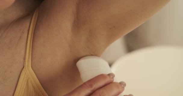 Extreme közelkép lövés, egy nő látható alkalmazása szilárd dezodor az ő hónalj pontossággal. A kamera rögzíti a dezodorbot sima siklását, miközben könnyedén bevonja a bőrét.. - Felvétel, videó
