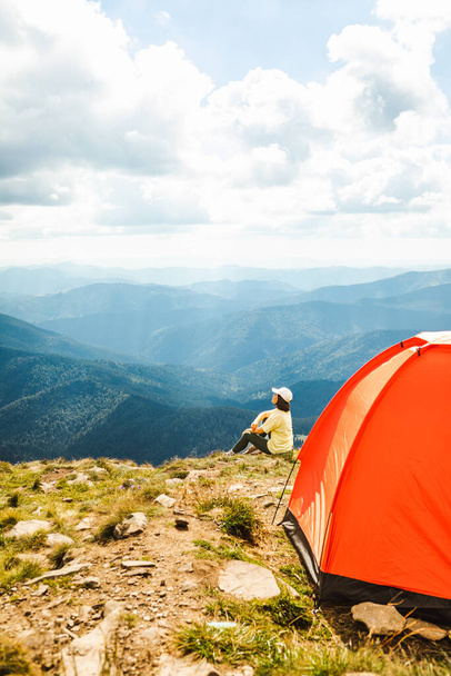 Nainen, jolla on teltta vuoren huipulla - Valokuva, kuva