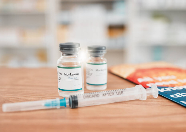 Pharmacy, syringe and vial of vaccine for cure, medication or monkeypox in healthcare on table. Drugs, needle and pharmaceutical product on desk for vaccination, flu shot or equipment at the clinic. - Photo, Image