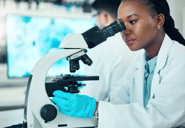 Microscoop, wetenschap en vrouwelijke wetenschapper in een lab voor medisch farmaceutisch onderzoek. Professionele, wetenschappelijke en Afrikaanse vrouwelijke onderzoeker die werkt aan moleculaire analyse met biotechnologische apparatuur - Foto, afbeelding