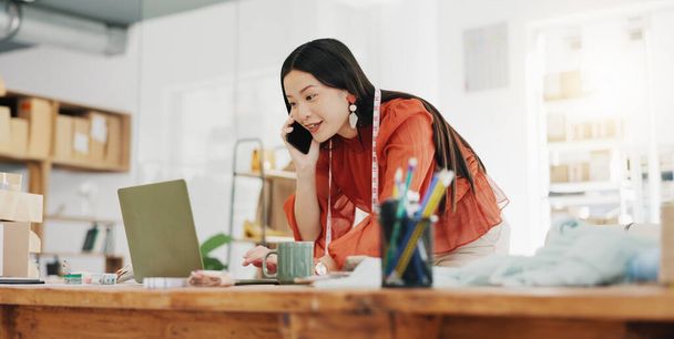 Telefonhívás, laptop és kreatív egy tervező ázsiai nő a munkahelyén az ő divat iroda egy stílus érdekében. Kapcsolat, e-kereskedelem és design egy női alkalmazott beszél a telefonján a kiskereskedelmi. - Fotó, kép
