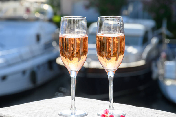 Soirée estivale, dégustation de champagne rose brut français mousseux dans des verres dans le port de plaisance de Port Grimaud près de Saint-Tropez, vacances sur la Côte d'Azur, Var, France - Photo, image
