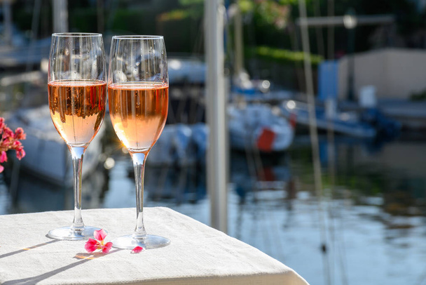 Nyári party, ivás francia brut rózsa pezsgő pezsgő pezsgő poharakban jacht kikötő Port Grimaud közelében Saint-Tropez, Francia Riviéra nyaralás, Var, Franciaország - Fotó, kép