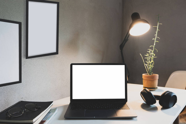 Home office com laptop e livro sobre mesa decoração moldura branca como luz de lâmpada e plantas de casa com parede estilo loft decorações interiores. de perto - Foto, Imagem