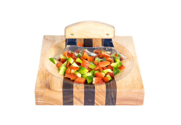 Ulu mes en gehakte rode en groene paprika op een houten blok geïsoleerd - Foto, afbeelding