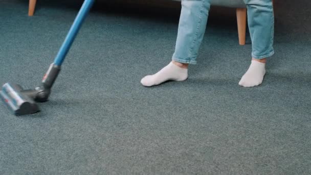 Primer plano de la aspiradora aspiradora alfombra en apartamento moderno. Mujer joven para mantener la casa ordenada en casa en la sala de estar. Limpieza de casas, concepto de tareas domésticas. Imágenes de 4k - Metraje, vídeo