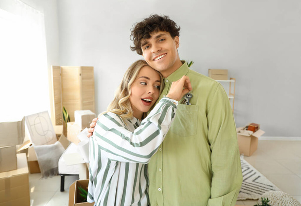 Νεαρό ζευγάρι με κλειδιά από το νέο τους διαμέρισμα στο υπνοδωμάτιο την ημέρα της μετακόμισης - Φωτογραφία, εικόνα
