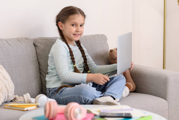 自宅でコンピュータサイエンスをオンラインで勉強するラップトップを持つ小さな女の子 - 写真・画像