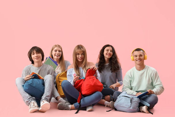 Группа студентов, сидящих на розовом фоне - Фото, изображение
