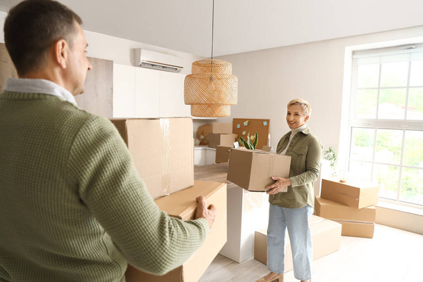 Mature couple with cardboard boxes in kitchen on moving day - Photo, Image