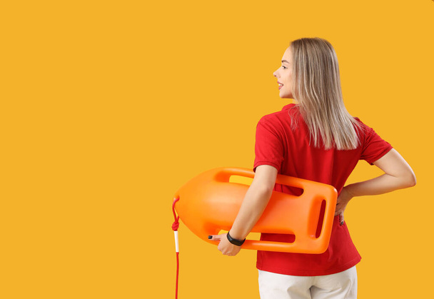 salva-vidas feminino com bóia de resgate no fundo amarelo, visão traseira - Foto, Imagem