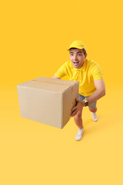 Mies kuriiri Paketti käynnissä keltainen tausta - Valokuva, kuva