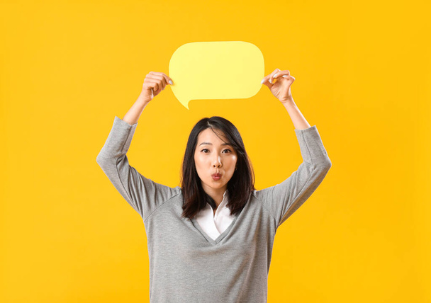 Mulher asiática cuidadosa com bolha de fala em branco no fundo amarelo - Foto, Imagem