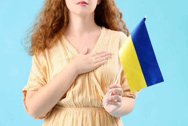 Piękna młoda kobieta z ukraińską flagą na niebieskim tle - Zdjęcie, obraz