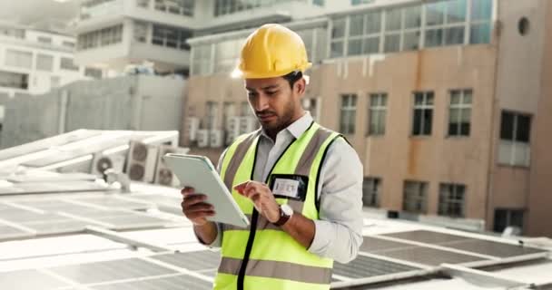 Tablet, Solarmodul und ein Bauarbeiter auf einem Dach in der Stadt, um alternative Energieanlagen, Technologie, Gebäude und Nachhaltigkeit mit einem Ingenieur oder Elektriker bei der Arbeit zu installieren. - Filmmaterial, Video