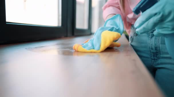 Primo piano colpo di casalinga in guanti di gomma blu lava, spruzzando davanzale della stanza controsoffitto con uno straccio giallo bagnato con detergente - Filmati, video