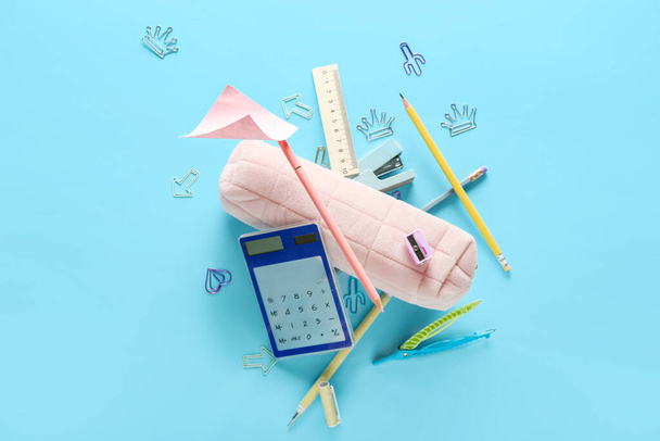 Pencil case and different stationery flying on color background - Photo, Image