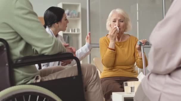 Mulher idosa branca chorando durante sessão de terapia de grupo com especialista em casa de repouso - Filmagem, Vídeo