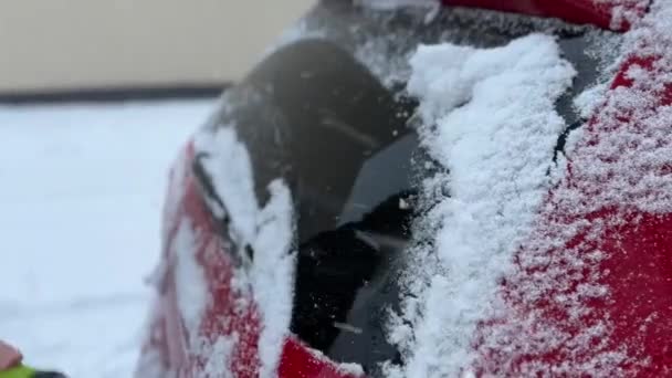 Κοντινό πλάνο αυτοκινήτου καλυμμένου με χιόνι και με παγωμένα παράθυρα να ξεπλένονται από το χιόνι. - Πλάνα, βίντεο