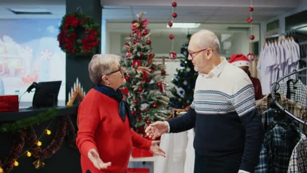 Gelukkig ouder stel dansend rond in kerstmis sierlijke winkelcentrum kledingwinkel, eindelijk het vinden van perfecte geschenken voor familieleden op kerstbijeenkomst tijdens de wintervakantie - Video