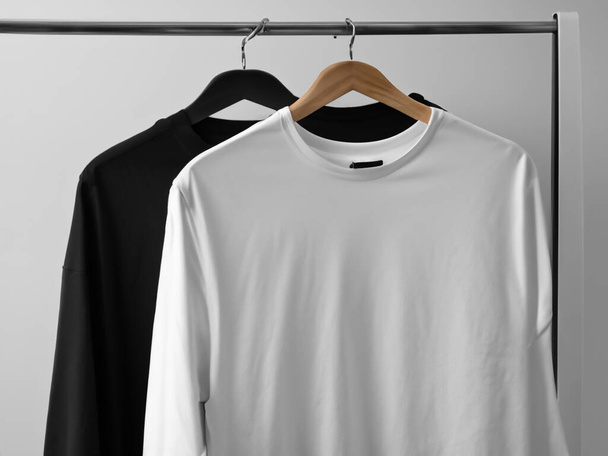 Ρεαλιστικό mockup t-shirt | Λευκά ασπρόμαυρα t-shirt σε κρεμάστρα, σχέδιο mockup. Καθαρίστε απλό βαμβακερό t-shirt mock up πρότυπο. Ένδειξη εικονικού σήματος λογότυπου του καταστήματος Apparel - Φωτογραφία, εικόνα