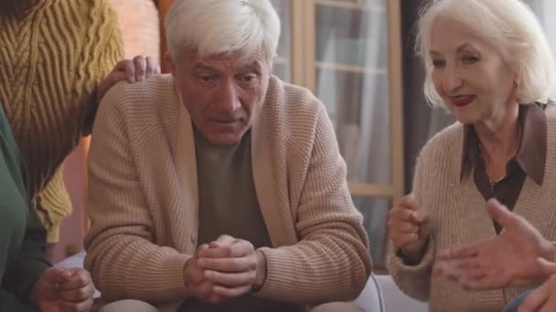 Emocionado hombre mayor caucásico tirar dados mientras juega juego de mesa con amigos en el hogar de ancianos - Imágenes, Vídeo