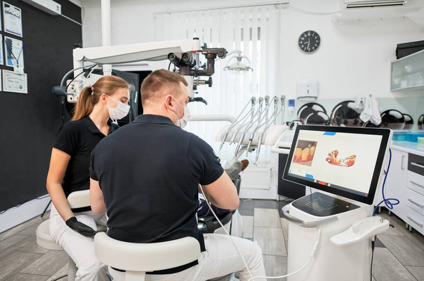 Scansione dentistica dei denti dei pazienti con moderna macchina per la scansione intraorale. La stampa digitale dei denti dei pazienti è sul grande schermo. Moderne tecnologie di alta precisione. Concetto di odontoiatria moderna - Foto, immagini