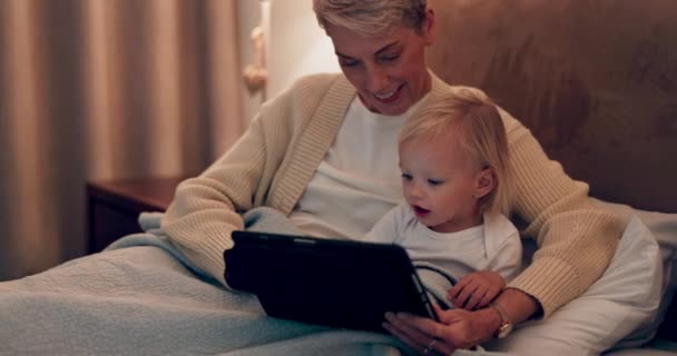Γυναίκα, μωρό και παιδί χαλαρώνουν με tablet στην κρεβατοκάμαρα για να παρακολουθήσουν μια παιδική ταινία, τηλεοπτική εκπομπή ή βίντεο στο σπίτι της οικογένειας. Μητέρα, παιδί και μαζί σε ταινίες streaming στο κρεβάτι στα social media ή mobile app για εκπαίδευση. - Πλάνα, βίντεο
