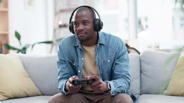 Man, headphones and video game with controller, sofa and excited for virtual user experience, streaming or esports. Young guy, online gaming and thinking with press, click and strategy for challenge. - Footage, Video