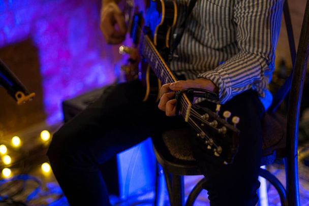 Τα χέρια του κιθαρίστα παίζουν ηλεκτρική κιθάρα. Υψηλής ποιότητας φωτογραφία - Φωτογραφία, εικόνα