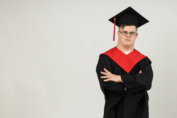 Jovem sorridente com paralisia cerebral usando óculos em um terno de pós-graduação. Conceito do Dia Mundial das Doenças Genéticas, lugar para texto - Foto, Imagem