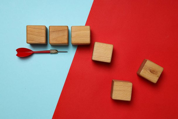 Cubi e freccette in legno su sfondo rosso, vista dall'alto - Foto, immagini