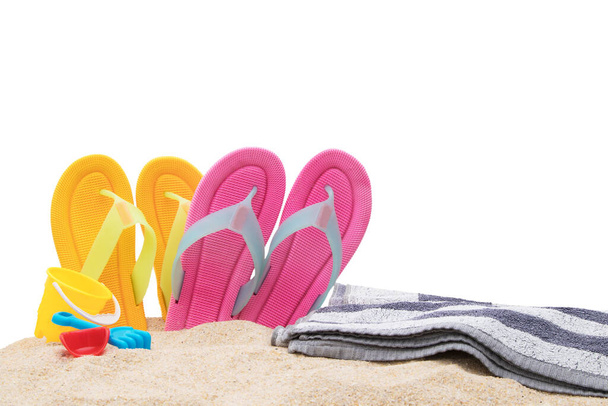 пляжная обувь с полотенцем и игрушки изолированы на белом - Фото, изображение