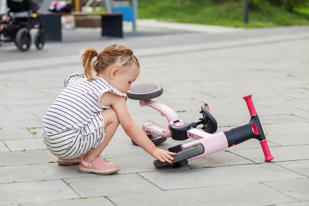 Toddler girl driving balance bike outdoors. Learning to ride bike concept. - Photo, Image