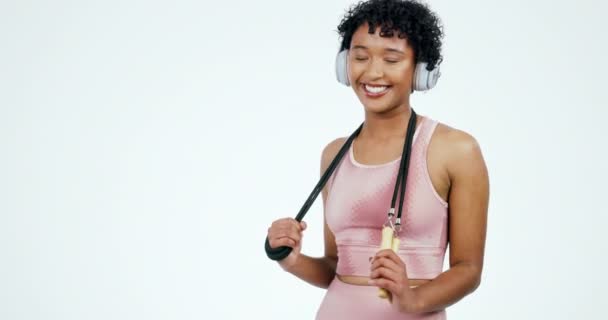 İp atlama, mutlu ve kulaklıklı kadın egzersiz, egzersiz ve egzersiz için beyaz arka planda. Stüdyoda müzik, radyo ve ses dinleyen kişinin spor ve portresi atlamak için. - Video, Çekim