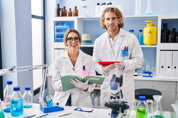 Deux personnes travaillant au laboratoire scientifique souriant et riant fort à haute voix parce que drôle blague folle.  - Photo, image